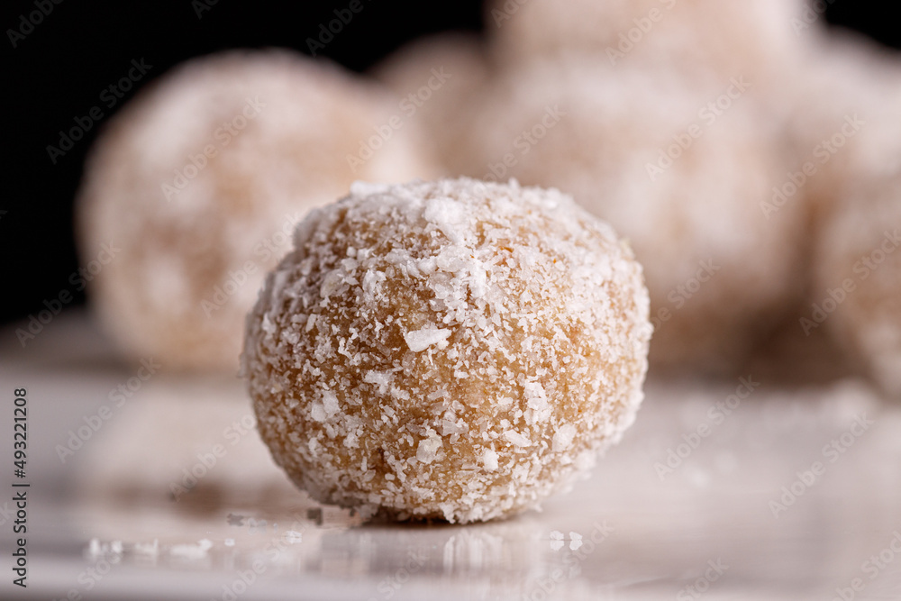 Beautiful sweets with coconut on a white plate on a black background Beautiful sweets with coconut on a white plate on a black background