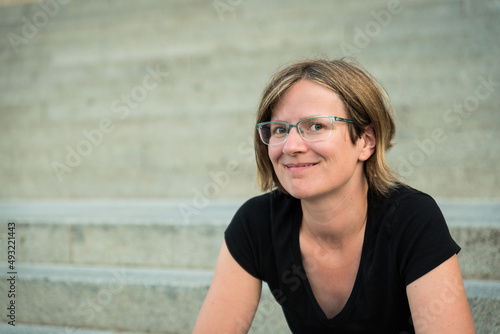 Portrait of a thirty year old white woman with a concrete stairs background photo