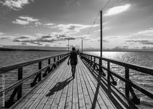Rattvik, Dalarna - Sweden -  Woman walking the straight lines of the Silvjan lake pier photo