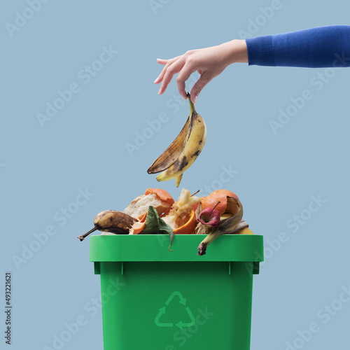 Woman putting organic waste in the recycling bin photo
