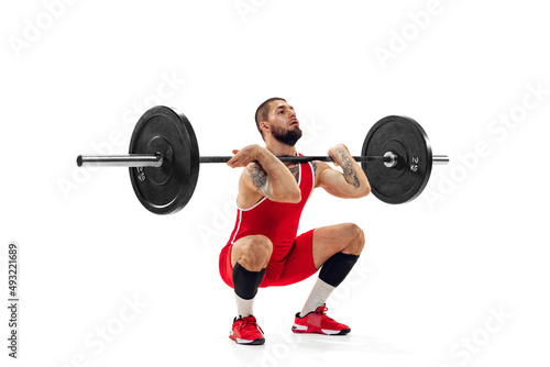 Full length portrait of man in red sportswear exercising with a weight isolated on white background. Sport  weightlifting  power  achievements concept