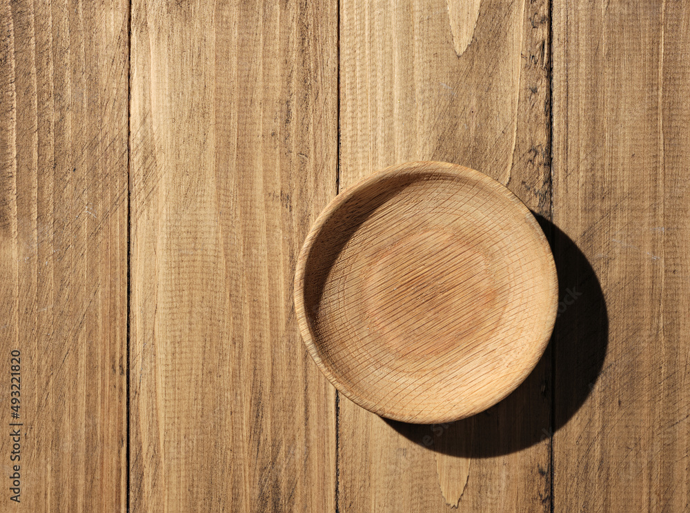 Wooden bowl on a wooden table - top view