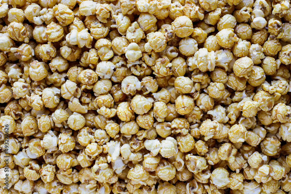 Overhead of close up shot of caramel popcorn for a popcorn background. Popular food for movie or cinema snacks. Flat lay. Overhead of close up shot of caramel popcorn for a popcorn background. Popular food for movie or cinema snacks. Flat lay.