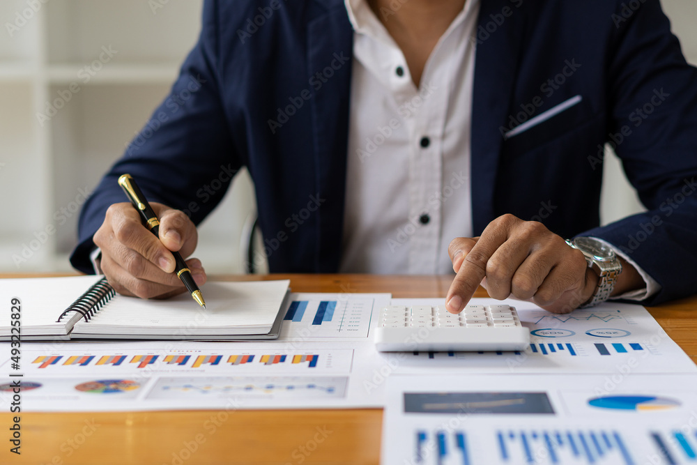 An accountant, businessman, or financial professional analyzes business report graphs and computational charts at the company's office. Banking business economy concept. and stock market research An accountant, businessman, or financial professional analyzes business report graphs and computational charts at the company's office. Banking business economy concept. and stock market research