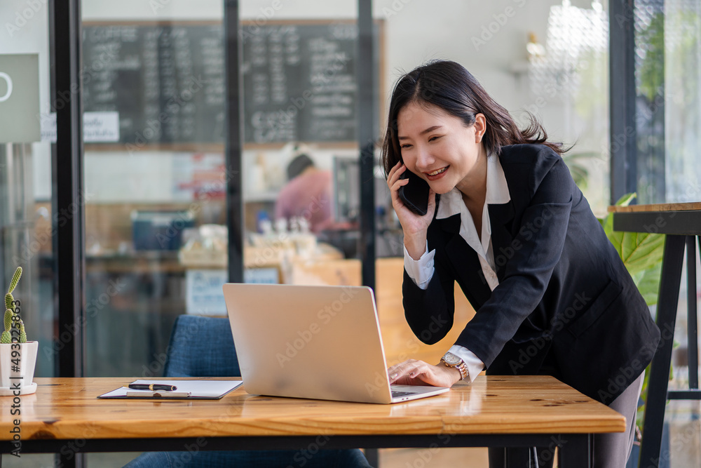 working concept Asian businesswoman using laptop Internet communication with customers at coffee shops Attractive woman sitting on laptop and smartphone in beverage restaurant working concept Asian businesswoman using laptop Internet communication with customers at coffee shops Attractive woman sitting on laptop and smartphone in beverage restaurant