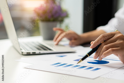 An accountant, businessman, or financial professional analyzes business report graphs and computational charts at the company's office. Banking business economy concept. and stock market research