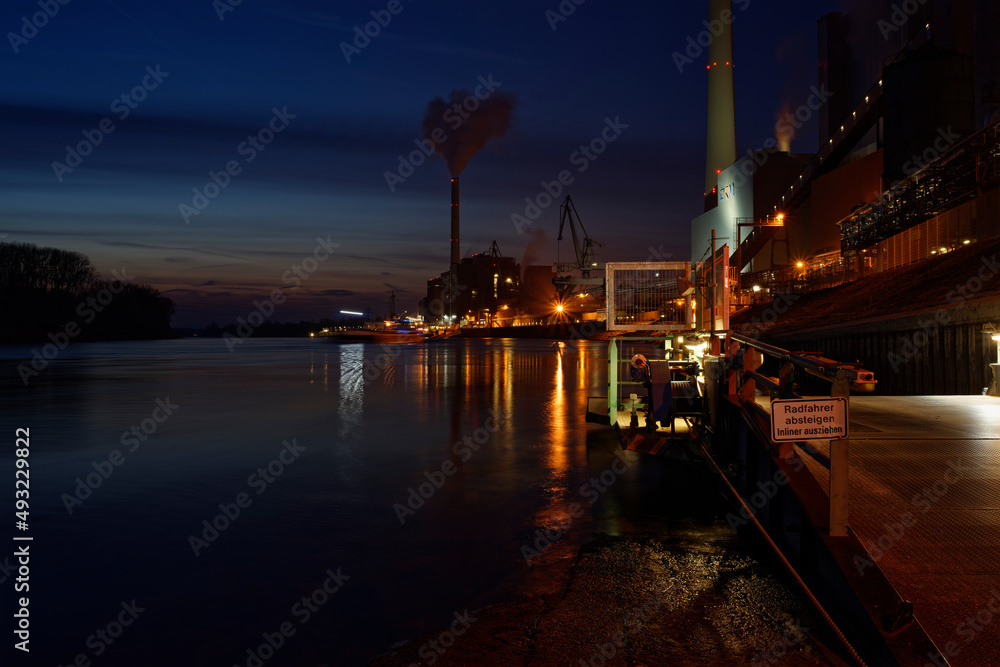 Coal power plant, large power plant at night with reflection in the Rhine.