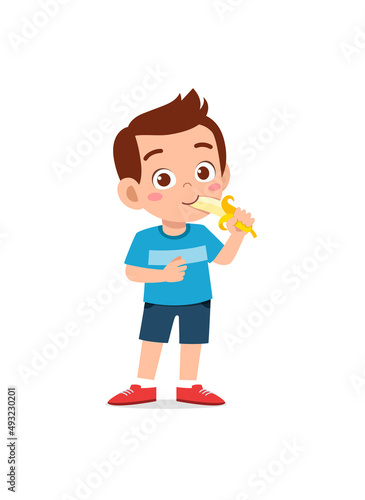 little boy standing and eating fresh banana