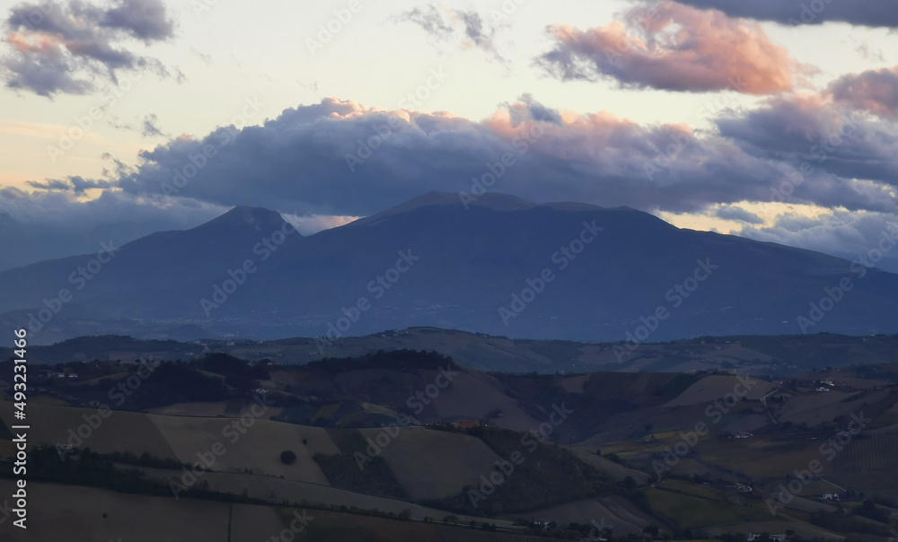 Nuvole colorate sopra la cima dei monti e le valli