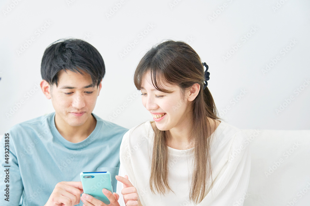 スマホを使うカップル リビング スマホを使うカップル リビング