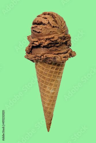 double scoops chocolate ice cream cone on green background