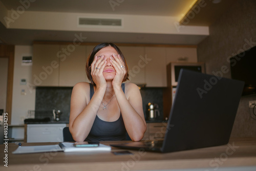 Frustrated sad woman feeling tired, worried about problem sitting at laptop, depressed girl worried about reading bad news online, debt notification email or negative message © YURII Seleznov
