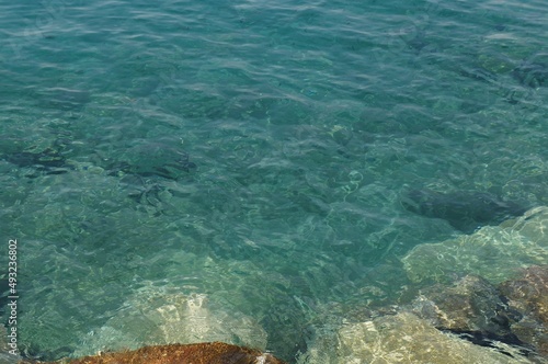 Clear sea water surface, stones and glare