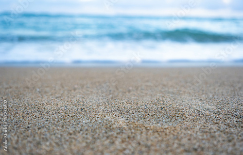 Tropical beach and blurred weaves with bokeh. Summer holiday background concept. Focus on sand. Copy space. 