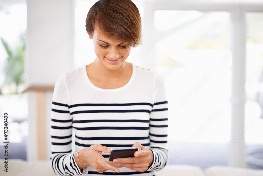 Too funny over text. Cropped shot of a young woman smiling at a text she received. Too funny over text. Cropped shot of a young woman smiling at a text she received.