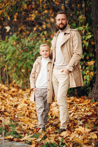 Dad and son in autumn  stylishly dressed  walking in the park