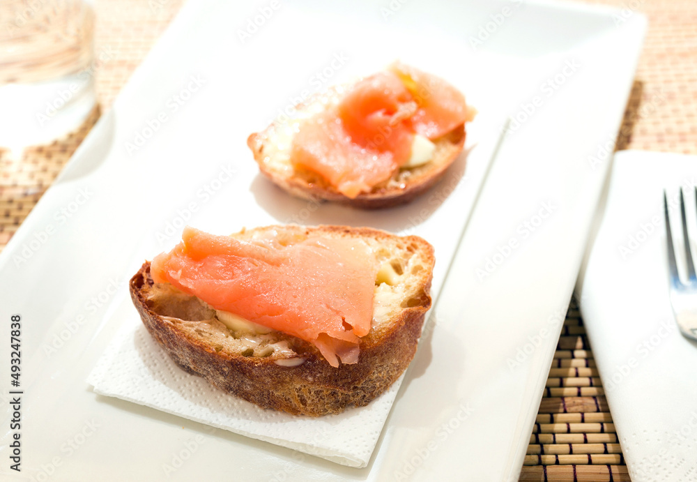 delicious canapes of salted, smoked salmon fillet on slice of fresh ciabatta bread delicious canapes of salted, smoked salmon fillet on slice of fresh ciabatta bread