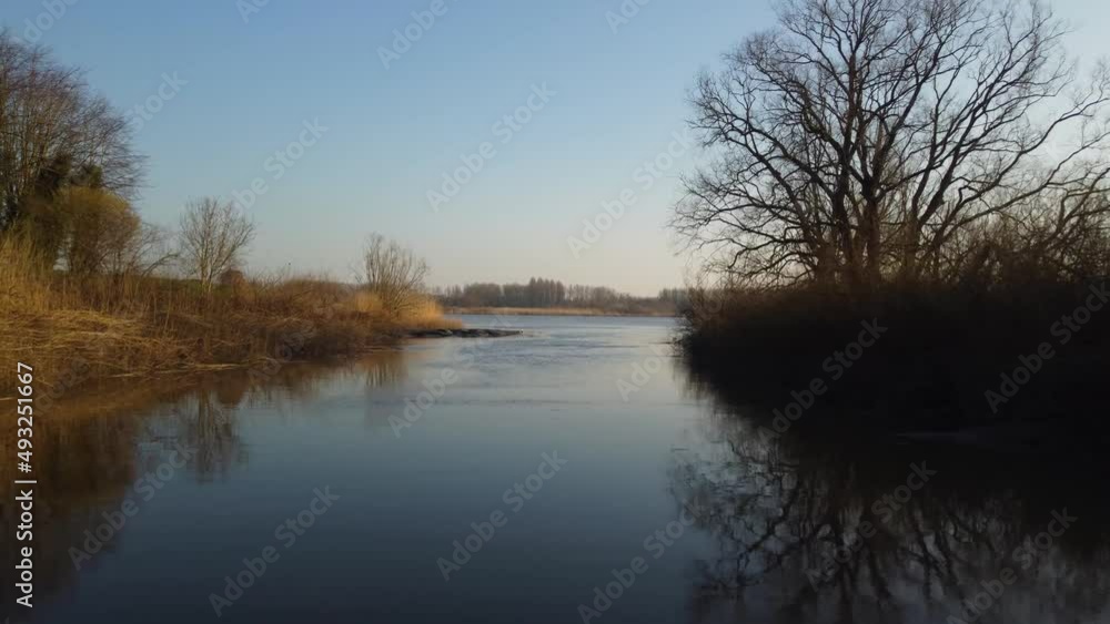 Narrow side stream culminating in river Scheldt, aerial fly forward view Narrow side stream culminating in river Scheldt, aerial fly forward view