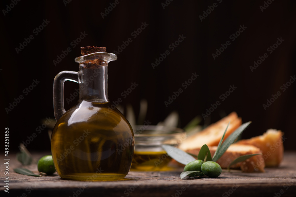 Olive oil with branch on the wooden background Olive oil with branch on the wooden background