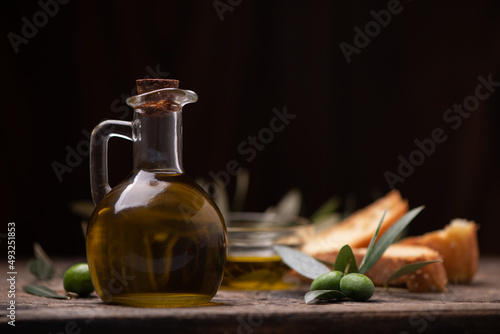 Olive oil with branch on the wooden background