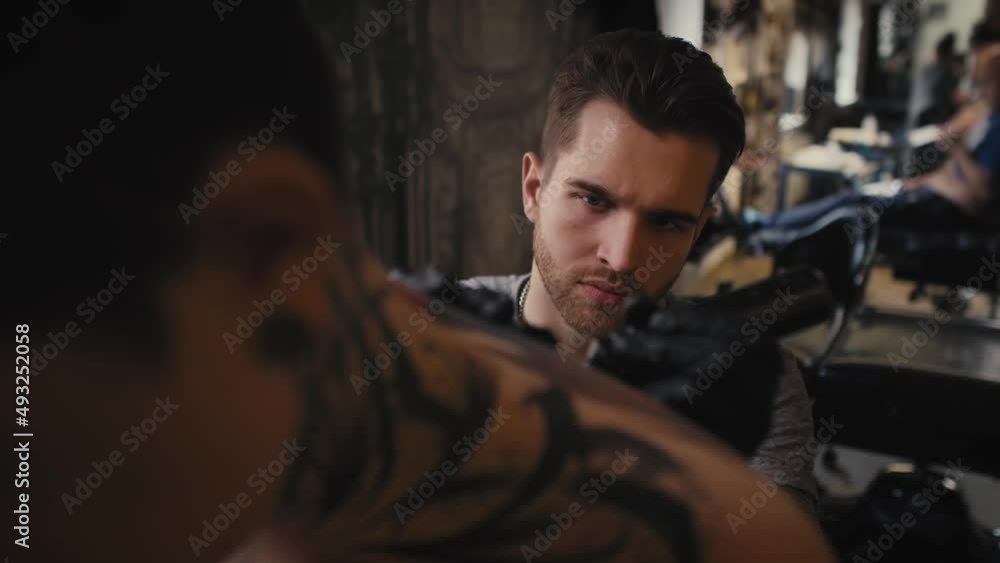 Focus caucasian man tattooing woman at the studio. Shot with RED helium camera in 8K. Focus caucasian man tattooing woman at the studio. Shot with RED helium camera in 8K.