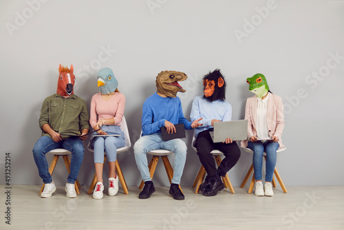 People with animal faces sitting in line waiting for job interview. Applicants in funny silly masks reading CVs and resumes and using laptops. College or university students discussing test or exam