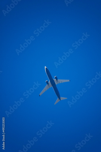Commercial flight plane against blue sky.