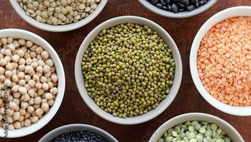 Mung bean and other dry beans and lentils in bowls. Table spin, top view.