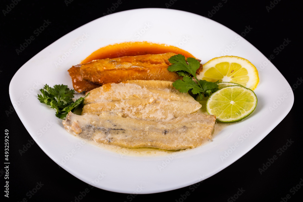 herring fillets on a plate with two kinds of sauce with lemon and lime herring fillets on a plate with two kinds of sauce with lemon and lime