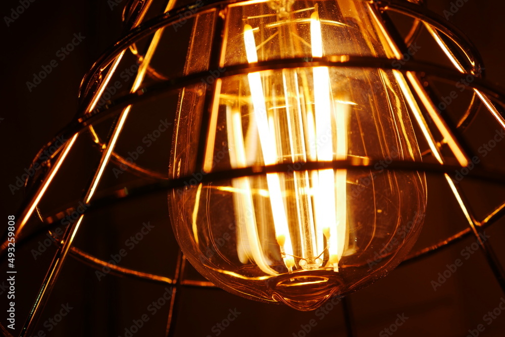 Vintage old light bulb glowing yellow on  dark background 