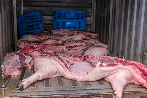 Fresh raw pork and offals of several whole pigs transport by truck for the market in china. Meat of the domestic pig. photo