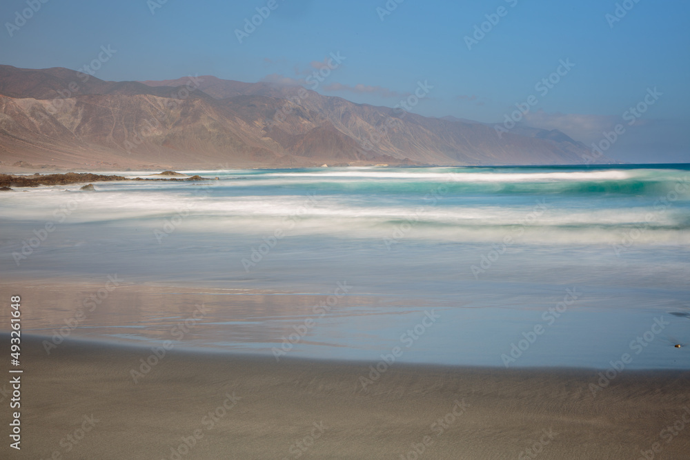 Long exposure image of a landscape with beach, sea and mountains at the Pacific coast of nortwest Chile