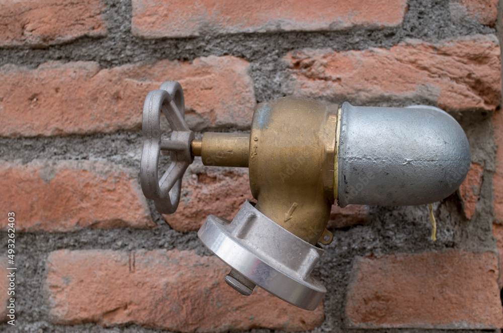 Fire hydrant and a house wall close Fire hydrant and a house wall close