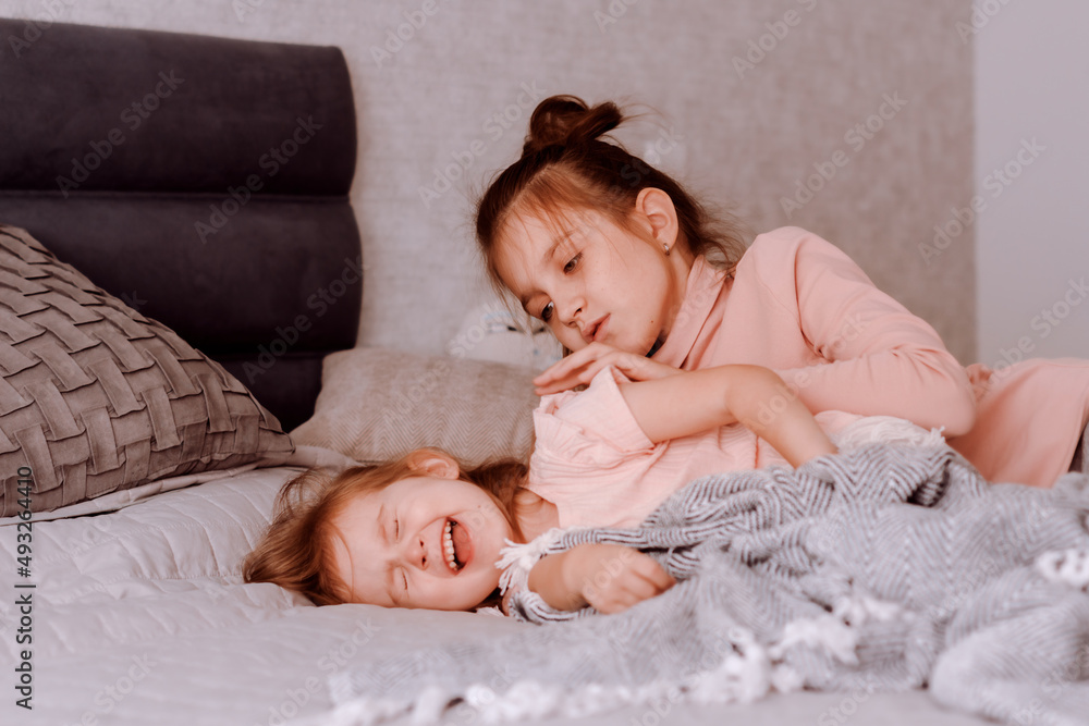 Big older sister puts the younger one to bed, nursing her. Family relationships full of true care and love Big older sister puts the younger one to bed, nursing her. Family relationships full of true care and love