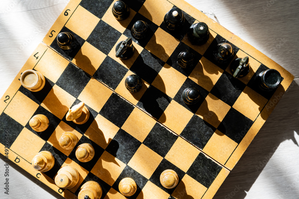 Top view of figures on chessboard on wooden background. Top view of figures on chessboard on wooden background.