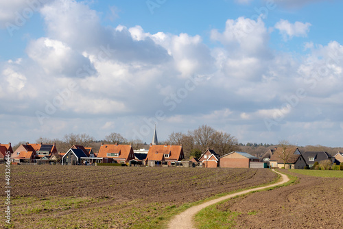 Traditional houses, Church under blue sky and clouds in small town, Holten is a village in the municipality of Rijssen-Holten in the Dutch province of Overijssel, Countryside landscape in Netherlands. photo