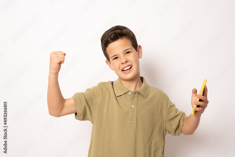 Excited caucasian boy in green polo shirt using smartphone isolated over white background. Excited caucasian boy in green polo shirt using smartphone isolated over white background.