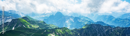 Panoramic view from Nebelhorn in Oberstdorf Allg  u Bavaria Germany - Beautiful Alps with lush green meadow and blue sky - Mountains landscape background banner panorama
