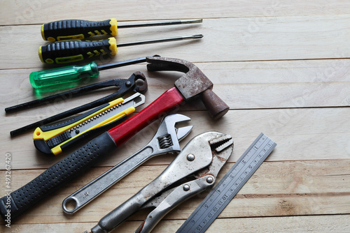 Different tools for construction working and general mechanic work isolated on wooden background closeup.