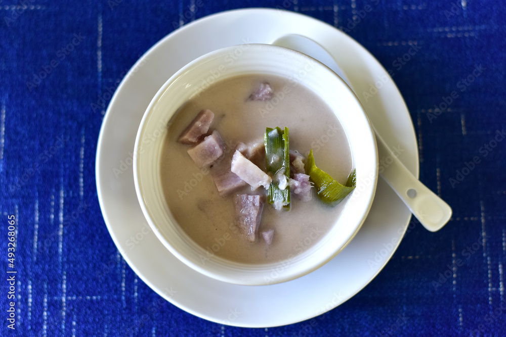 Top view of Sweet potatoes in light ginger syrup or Thai Dessert is Mun Tom King with Pandan Leaves in a white bowl. Close up Top view of Sweet potatoes in light ginger syrup or Thai Dessert is Mun Tom King with Pandan Leaves in a white bowl. Close up