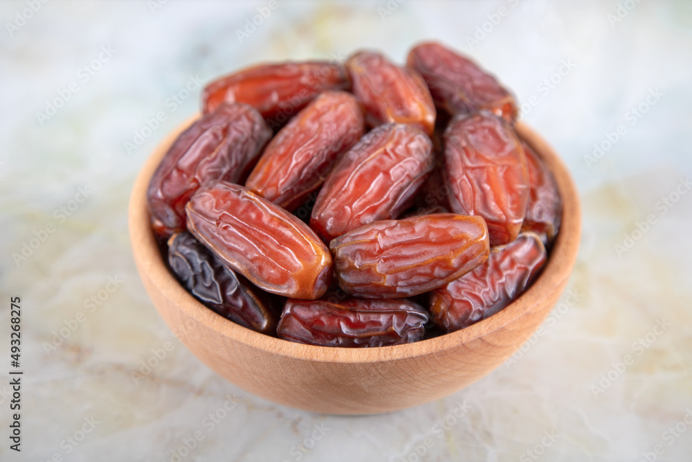 Bowl of dates fruit on colorful marble background, top view Bowl of dates fruit on colorful marble background, top view