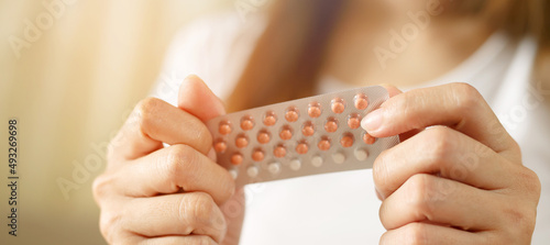 Woman hands opening birth control pills in hand. eating Contraceptive pill. Contraception reduces childbirth and pregnancy concept. Leave space to write descriptive text.