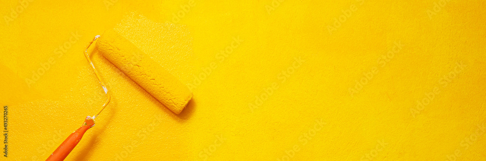 Obraz premium Painter is painting the interior wall yellow.