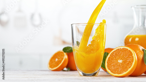 Foto Orange juice pouring into glass