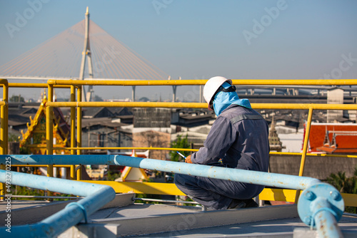 Male worker inspection recording visual roof storage tank oil