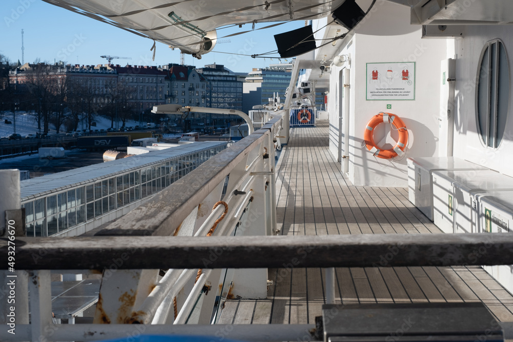 Closeup of a liferaft of a large passeger ferry. An outside walking promeade of a cruise ship.