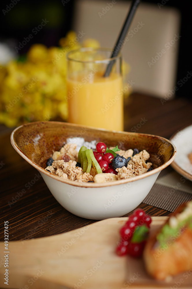 Dry breakfast with fresh berries,orange juice on background.Healthy meal,vertical photography. Dry breakfast with fresh berries,orange juice on background.Healthy meal,vertical photography.