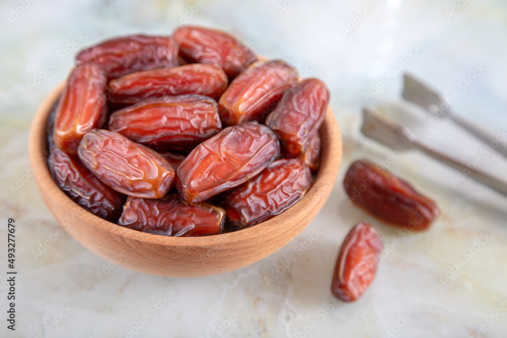 Bowl of dates fruit on colorful marble background, top view Bowl of dates fruit on colorful marble background, top view