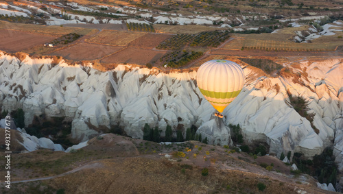 Aerial view of hot air balloon above a valley in sunrise, Cappadocia, Turkey