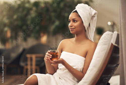 A spa day is good for your health. Shot of a woman drinking tea while enjoying a spa day. photo